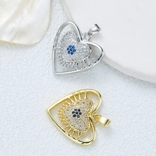 Detail of silver and gold heart pendants with blue zircon evil eye crystal stones