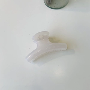 Close-up of a minimalist translucent milky white claw clip with a strong metal spring
