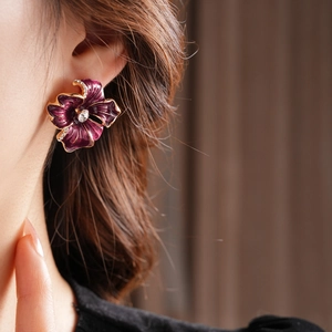 Detail of vintage flower stud earring with purple enamel petals and crystal center