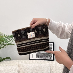 Macro shot of plush leopard print makeup bag showing soft faux fur texture and brand label