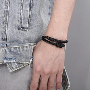 Close-up of a black twisted steel cable bracelet featuring a detailed snake head clasp design