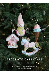 Detail of pink Christmas ice cream and snowman ornaments on a lit festive tree