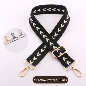 Close-up of adjustable woven shoulder strap with white arrow pattern and gold hardware