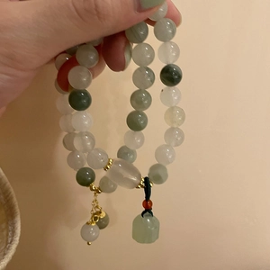 Macro view of jade beaded bracelet with lotus pendant and gold-tone spacers
