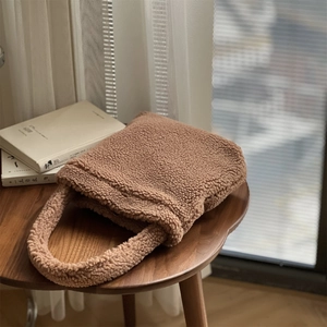 Macro view of brown plush teddy faux fur tote bag texture on a wooden table