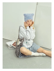 Detailed view of light blue fuzzy cat ear beanie styled with casual street fashion outfit