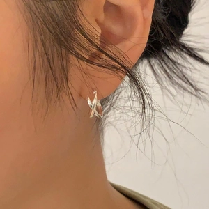 Minimalist 925 sterling silver interlocking hoop earrings worn on a female ear