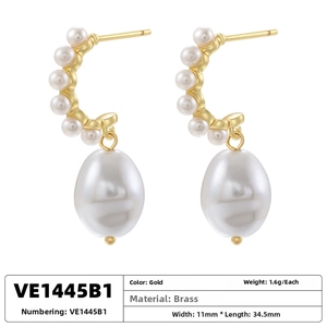 Detailed view of gold brass hoop earrings with rice pearls showing weight and size