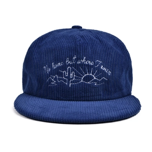 Detailed close-up of cactus embroidery on navy blue corduroy baseball cap texture