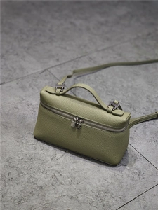 Top-down view of a green litchi grain leather handbag with metal lock and zipper