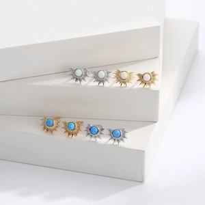 Macro detail of sunburst opal earrings in gold and silver plating on geometric stands