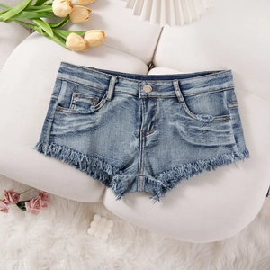 Flachbild von blauen Denim-Shorts mit ausgefransten Kanten auf weichem Hintergrund mit Blumen
