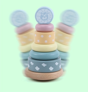 Detail of wooden rainbow stacker toy showing smooth macaron rings and lion head topper