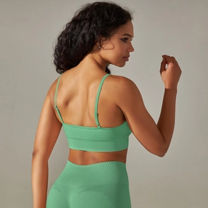 Detail of green seamless knitted yoga set with cross straps and ribbed waist texture