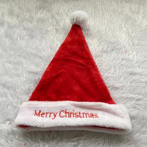 Detail of red plush Santa hat featuring white embroidered Merry Christmas text