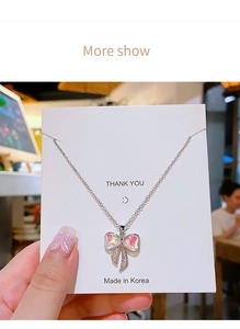 Dettaglio macro della collana con pendente a fiocco aurora e micro cristalli su carta