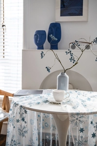Detailed close-up of white lace tablecloth with blue and silver snowflake patterns
