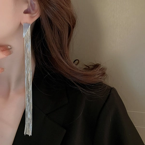 Detail of silver long tassel triangle earrings shown on model for elegant face framing