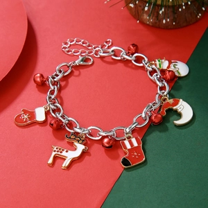Detailed view of Christmas charm bracelet with elk and snowflake pendants on festive backdrop