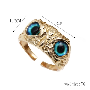 Detail view of gold owl ring featuring turquoise eyes with size and weight annotations