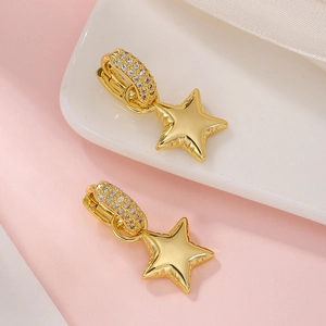 Detailed close-up of gold-plated star drop earrings with sparkling cubic zirconia pavé