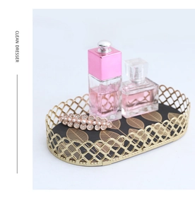 Detail of gold metal mesh tray with black leaf pattern base for jewelry display