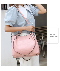 Detailed macro view of pink crocodile embossed texture on large capacity tote handbag