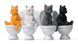 Detailed macro view of four creative resin cat figurines sitting on miniature toilets