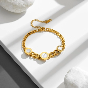 Gold chain bracelet with white shell Roman numeral circular pendants on a white stone