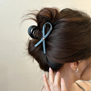 Pince à cheveux élégante avec nœud en denim bleu pour coiffure chignon sur modèle