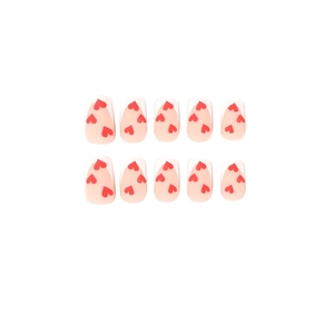 Matte French press-on nails with white tips and red heart patterns on pink base