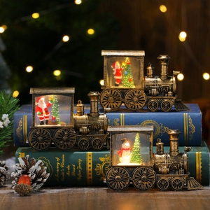 Vintage gold-brushed Christmas train lantern with Santa and snowman scenes on books