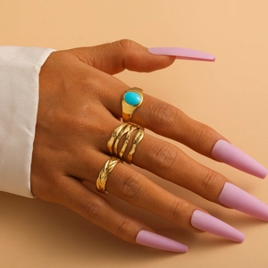 Close-up of gold titanium rings set featuring turquoise stone on model's hand