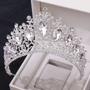 Detailed close-up of luxurious silver crown with clear crystals in a white gift box