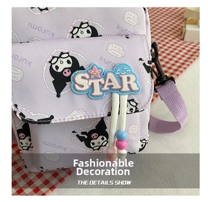 Detail showing the Kuromi print, STAR logo, and colorful charms on this purple crossbody bag