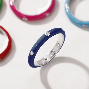 Close-up of deep blue enamel ring with sparkling round zircons and silver metal band