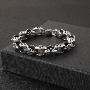 Gros plan d'un bracelet gothique en acier inoxydable avec des motifs de croix gravés