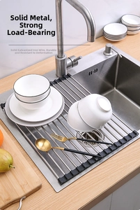 Close-up of a foldable stainless steel dish drying rack with solid metal rods over a sink