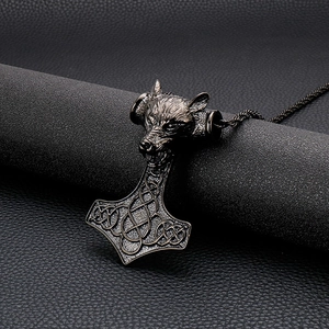 Gros plan du pendentif Mjölnir tête de loup en bronze avec nœuds celtiques sur cuir