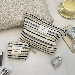 Striped canvas cosmetic bags in large and small sizes with a zip and handle detail