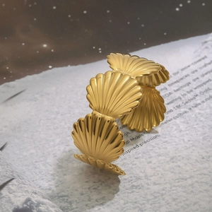 Chic gold stainless steel wide bangle featuring a scalloped seashell design and mirror finish