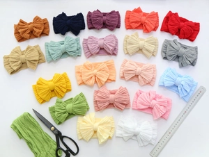 Flat lay of colorful nylon bow headbands for babies showing various vibrant color options