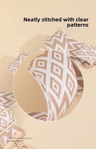 Close-up of geometric jacquard woven strap with neat stitching and light gold metal hooks