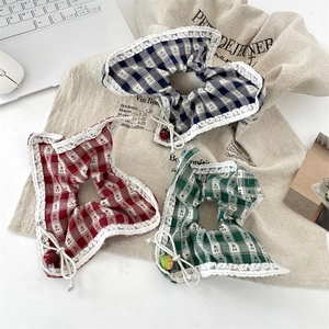 Three vintage plaid scrunchies in red, blue, and green with lace edges and cherry charms