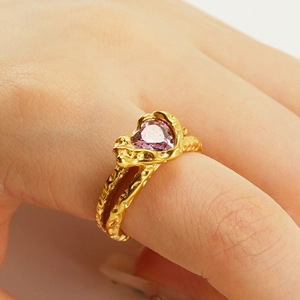 Detail of gold moonstone ring featuring a pink heart zircon and lava texture finish