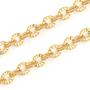 Macro detail of gold plated stainless steel sunburst chain links with faceted texture