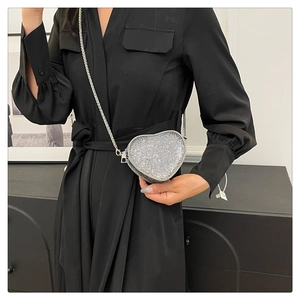 Detailed view of silver sequin heart-shaped crossbody bag with metal chain strap