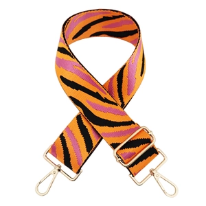 Close-up of adjustable woven tiger stripe bag strap with golden lobster clasps