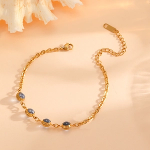 Close-up of 18k gold plated stainless steel bracelet with blue round cabochon stones