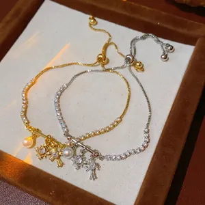 Adjustable zircon bracelet set with cross and pearl charms in gold and silver finish